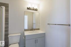 Bathroom vanity featuring a white countertop, undermount sink, and chrome faucet - 