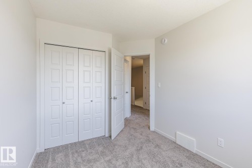 Spacious room featuring light gray walls, plush gray carpeting, and a white bi-fold closet - 3619 Triomphe Boulevard, Beaumont, AB - Indoor