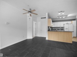 Open-concept living space featuring dark tile flooring and a ceiling fan - 
