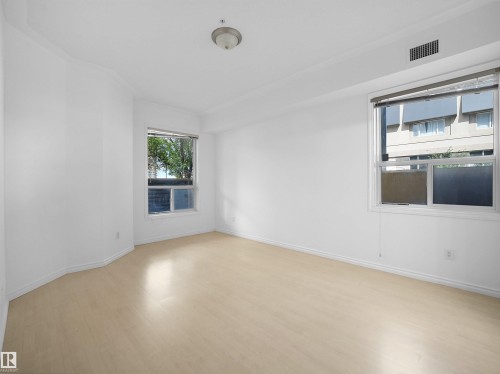 Bright interior space featuring light wood-finish flooring, white walls, and white baseboards - #207 10606 102 Av Nw, Edmonton, AB 