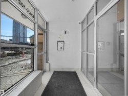 Commercial entryway featuring extensive glass paneling, full-light entry doors, and durable tile flooring - 