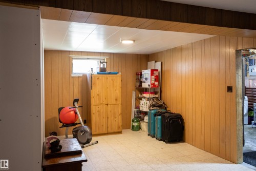 Finished room featuring wood paneling, a single window, and a tile floor - 10428 68 Avenue Nw, Edmonton, AB - Indoor