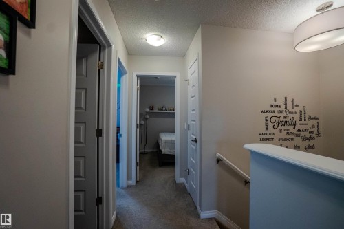 Hallway featuring neutral wall colors, carpeted flooring, and white trim - 1766 Dumont Crescent Sw, Edmonton, AB 