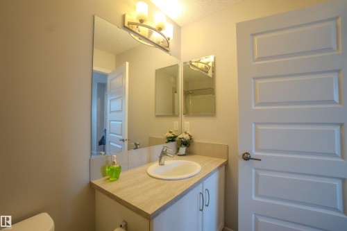 Bathroom vanity featuring a white ceramic sink, chrome faucet, and integrated cabinetry - 1766 Dumont Crescent Sw, Edmonton, AB 