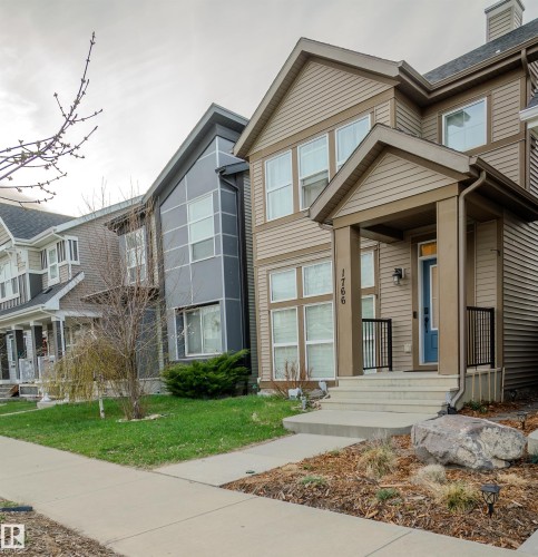 Contemporary dwelling featuring tan siding and a covered front porch with black railings - 1766 Dumont Crescent Sw, Edmonton, AB 