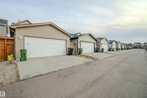 Detached garage featuring panel siding and a wood privacy fence - 1766 Dumont Crescent Sw, Edmonton, AB 