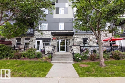 Modern multi-story building featuring stacked stone and grey paneling facade - #406 8525 91 St Nw, Edmonton, AB 