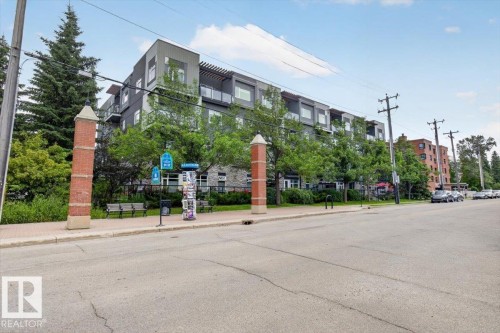 Modern multi-story building featuring a facade of grey paneling and stone accents - #406 8525 91 St Nw, Edmonton, AB 