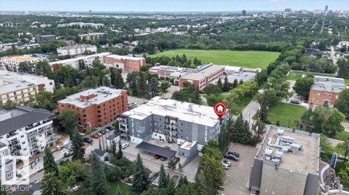 Modern multi-story building featuring a grey facade, private balconies, and covered parking - #406 8525 91 St Nw, Edmonton, AB 