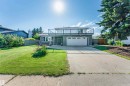 Contemporary exterior featuring a full-width upper-level balcony with glass railings, an integrated two-car garage, and a bay window - 5212 142 Street Nw, Edmonton, AB 