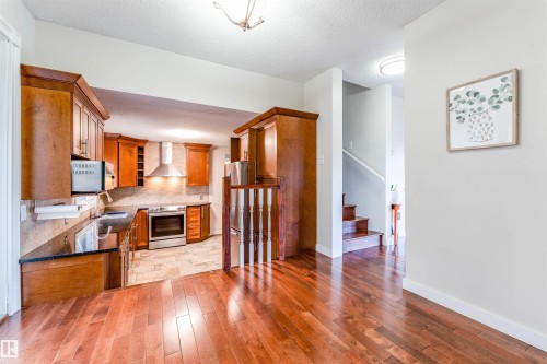 Kitchen featuring wood cabinetry, stainless steel appliances, and a tile backsplash - 5212 142 Street Nw, Edmonton, AB - Indoor