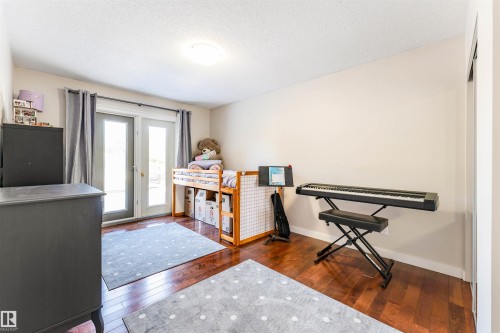 Room featuring wood-finish flooring, light-toned wall paint, and a flush-mount ceiling light - 5212 142 Street Nw, Edmonton, AB - Indoor