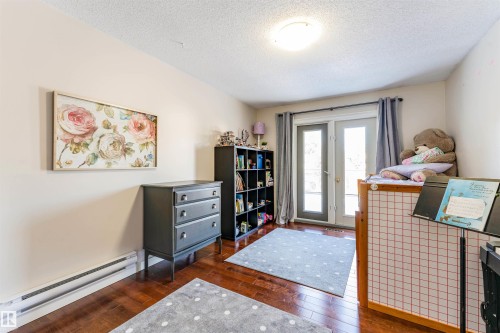 Room featuring wood-finish flooring, light-toned wall paint, and a ceiling-mounted flush light fixture - 5212 142 Street Nw, Edmonton, AB - Indoor