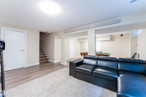 Spacious lower-level area with wood-finish flooring and light-toned walls - 5212 142 Street Nw, Edmonton, AB - Indoor