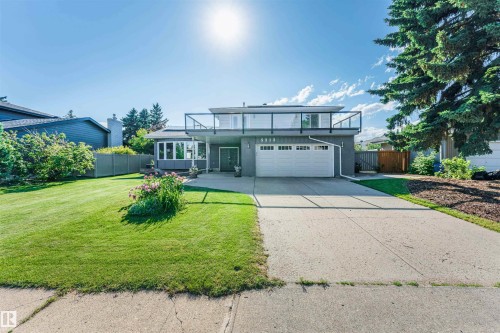 Contemporary exterior featuring a full-width upper-level balcony with glass railings, an integrated two-car garage, and a bay window - 5212 142 Street Nw, Edmonton, AB - Outdoor