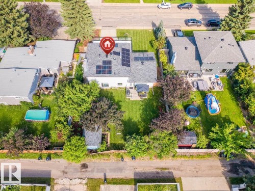 Spacious property featuring a large backyard with mature trees, expansive lawn space, and two sheds - 5212 142 Street Nw, Edmonton, AB - Outdoor With View