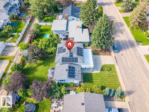Residential property featuring a grey shingle roof with multiple solar panels - 5212 142 Street Nw, Edmonton, AB - Outdoor With View