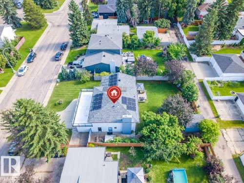 Property featuring a shingled roof with solar panels, an expansive backyard, and mature landscaping - 5212 142 Street Nw, Edmonton, AB - Outdoor With View