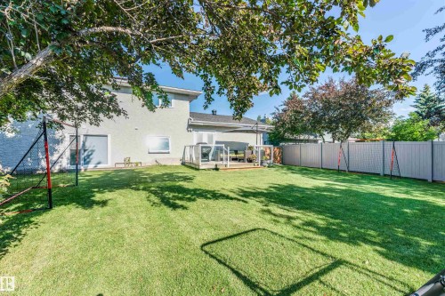 Expansive green lawn with mature trees and a private rear fence - 5212 142 Street Nw, Edmonton, AB - Outdoor With Deck Patio Veranda With Backyard