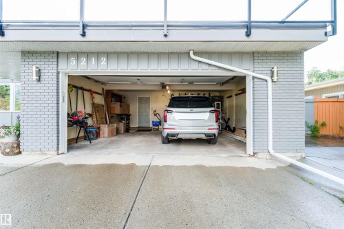 Attached two-car garage featuring a concrete driveway and light gray brick exterior - 5212 142 Street Nw, Edmonton, AB - Outdoor With Exterior