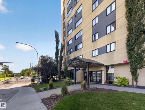Multi-story building with a modern facade featuring contrasting tan and gray panels - #502 9710 105 St Nw, Edmonton, AB 