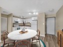 Open-concept kitchen featuring white cabinetry, white appliances, and track lighting - #502 9710 105 St Nw, Edmonton, AB 