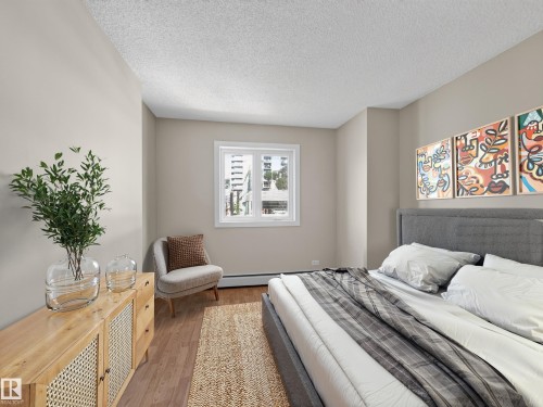 Bedroom featuring neutral wall tones and wood-finish flooring - #502 9710 105 St Nw, Edmonton, AB 