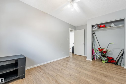 Room featuring wood-finish flooring, light gray wall paint, and white trim - 2437 89 Street Nw, Edmonton, AB 
