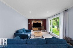 Spacious living area featuring light-toned flooring, recessed lighting, and crown molding - 
