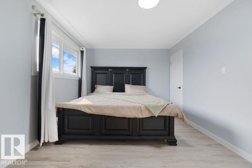 Light blue walls and wood-finish flooring create a bright interior - 27 Apache Crescent, Leduc, AB 