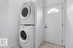 Dedicated laundry area featuring a stacked washer and dryer unit - 