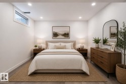 Recessed lighting illuminates this room featuring white walls and a light wood-finish flooring - 