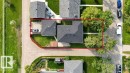 Aerial perspective showcasing the property's footprint with a detached garage, established trees, and a concrete driveway - 27 Apache Crescent, Leduc, AB 