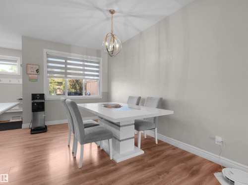 Dining area with wood-finish flooring and a contemporary pendant light fixture - #30 4137 76 St Nw, Edmonton, AB 