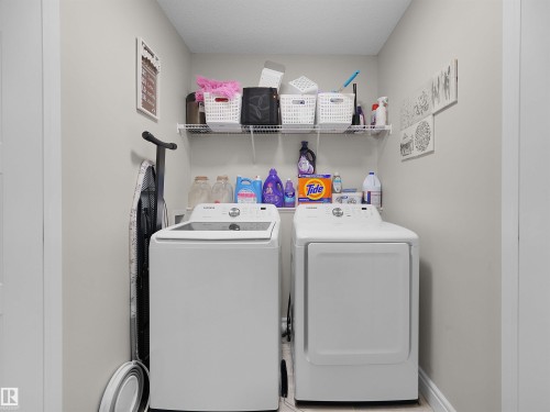 Dedicated laundry area featuring a white top-load washer and a white front-load dryer - #30 4137 76 St Nw, Edmonton, AB 