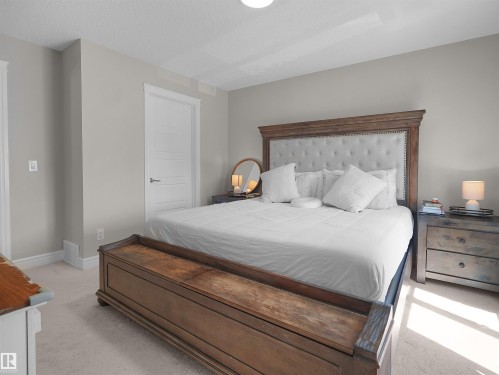 Spacious room featuring light-colored walls, soft carpeting, and a modern paneled door - #30 4137 76 St Nw, Edmonton, AB 