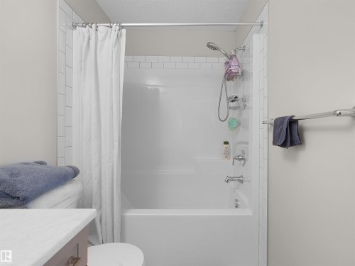 White subway tile surround framing a shower-over-tub combination with chrome fixtures - #30 4137 76 St Nw, Edmonton, AB 