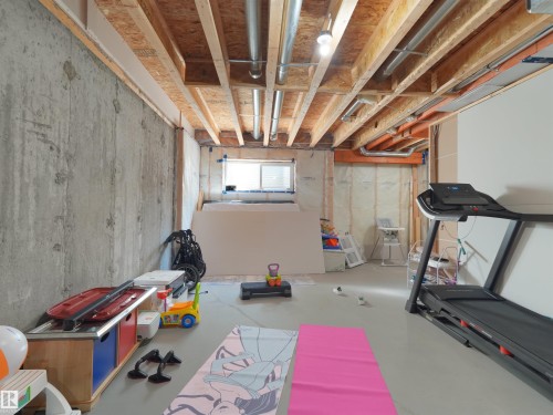 Unfinished basement space featuring exposed concrete walls and ceiling joists - #30 4137 76 St Nw, Edmonton, AB 