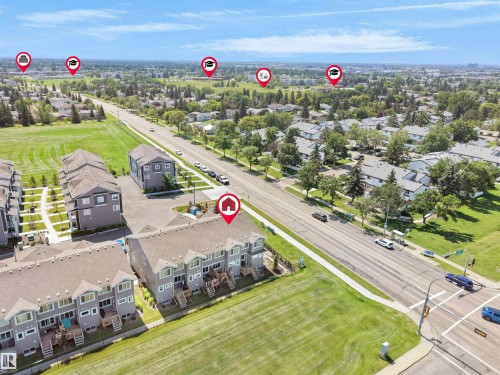 Aerial view of a residential area featuring multi-story townhomes with light gray siding and brown shingled roofs - #30 4137 76 St Nw, Edmonton, AB 