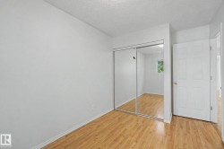 Interior room featuring wood-finish flooring, white walls, and a white ceiling - 