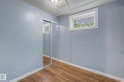 Room featuring wood-finish flooring, light blue walls, and white baseboards - 