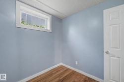 Room featuring wood-finish flooring, light blue walls, and white trim - 
