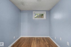 Room with light blue walls, wood-finish flooring, and white baseboards - 