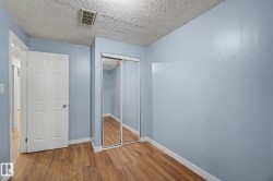 Interior room featuring wood-finish flooring, light blue walls, and white trim - 