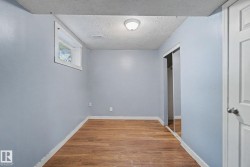 Room with wood-finish flooring, light blue walls, and white trim - 