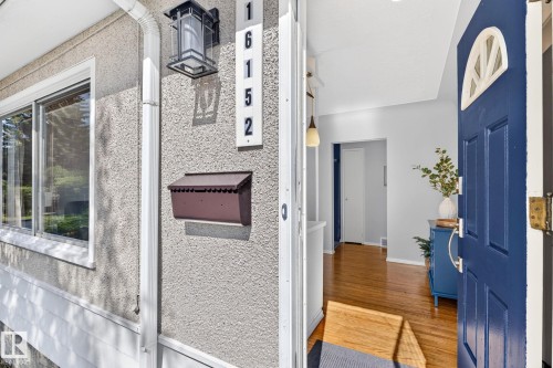 Entryway featuring a vibrant blue door with an arched transom window, a textured exterior finish, and prominent house numbers - 16152 110B Avenue Nw, Edmonton, AB - Indoor Photo Showing Other Room