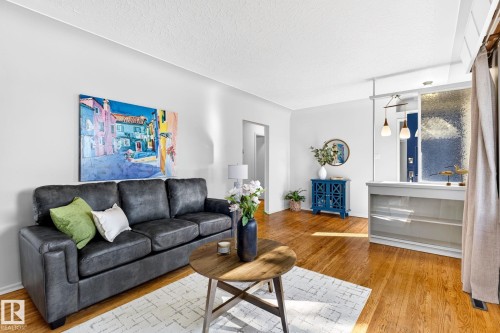 Hardwood flooring throughout a living area featuring bright white walls - 16152 110B Avenue Nw, Edmonton, AB - Indoor Photo Showing Living Room