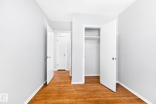 Hardwood flooring throughout, featuring a built-in closet with shelving and hanging rod - 16152 110B Avenue Nw, Edmonton, AB - Indoor Photo Showing Other Room