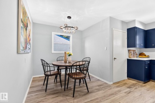 Dining area featuring wood-finish flooring and a contemporary circular chandelier - 16152 110B Avenue Nw, Edmonton, AB - Indoor Photo Showing Dining Room