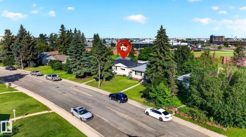 Residential property featuring a white exterior, dark roof, and mature landscaping - 16152 110B Avenue Nw, Edmonton, AB - Outdoor With View
